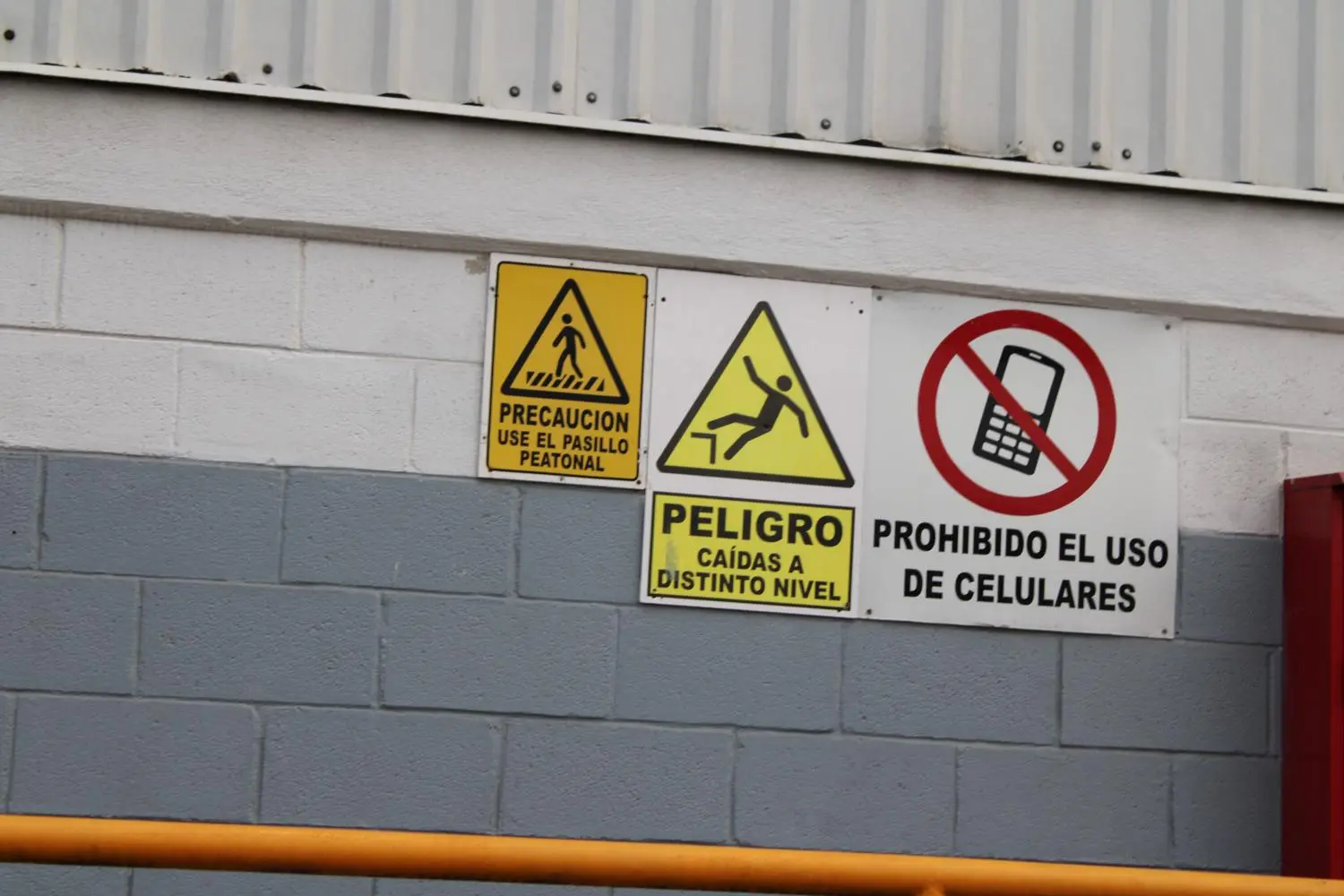 Señales de precaución, peligro y prohibición en un entorno industrial.