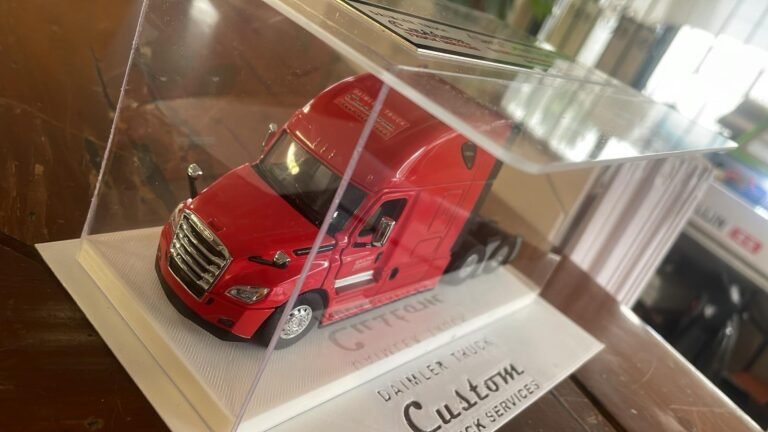 Modelo de camión rojo en caja transparente